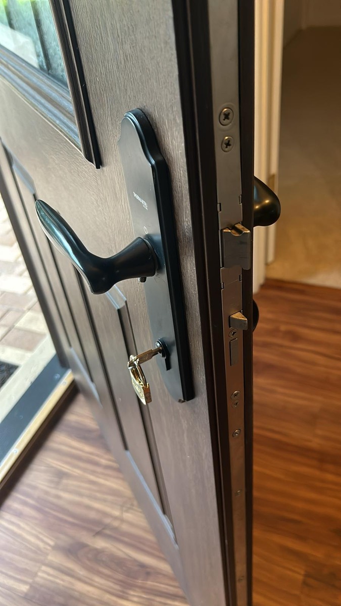 New black lever handleset installed on a home front door