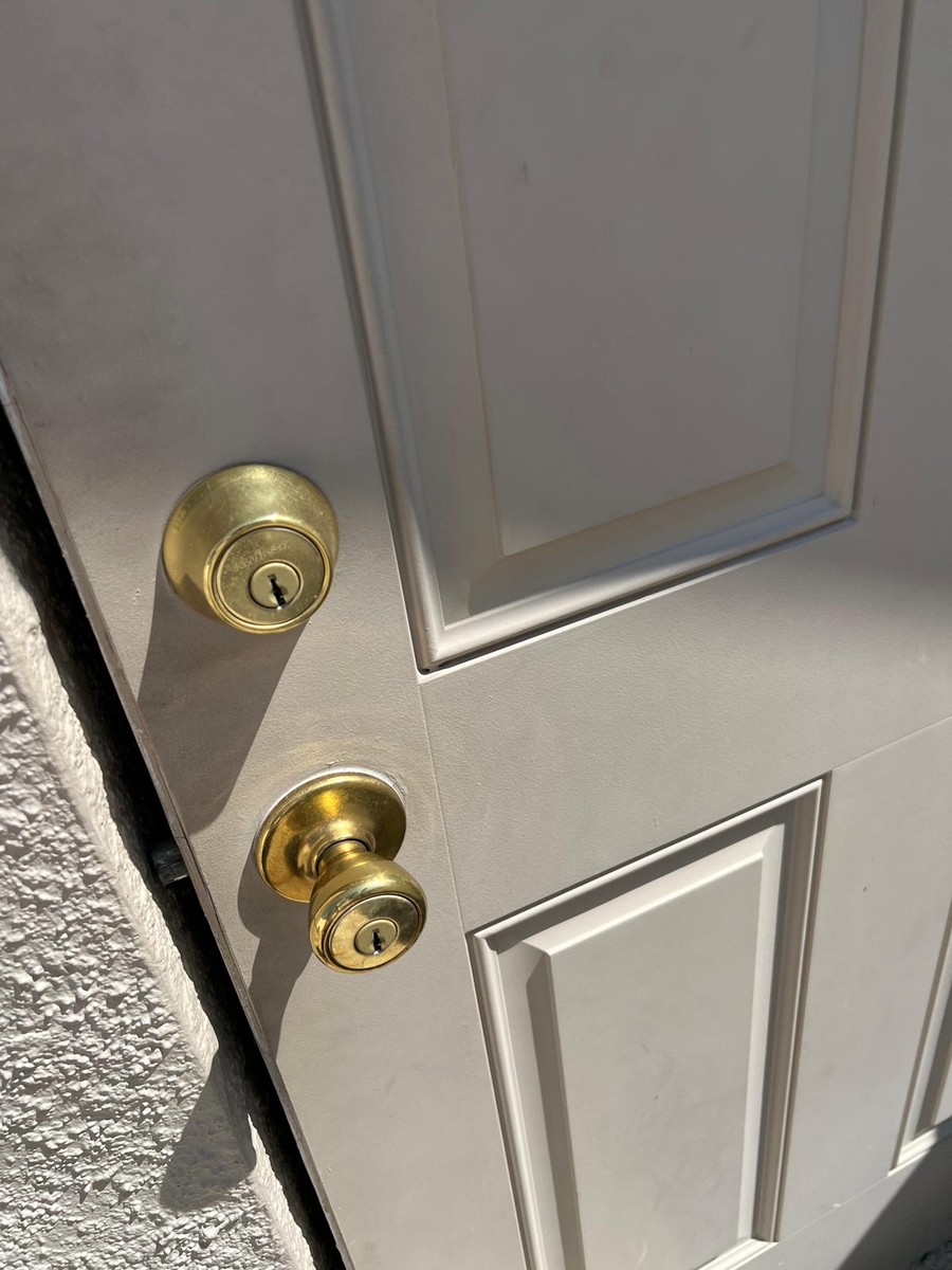 Brass deadbolt and knob on a freshly serviced entry door