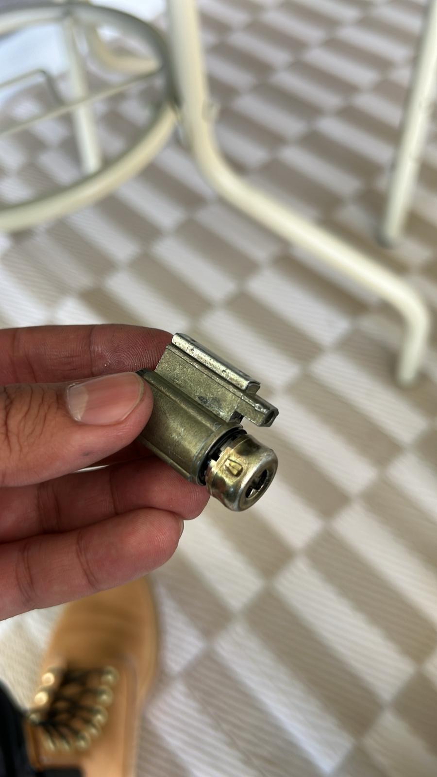 Locksmith holding a removed lock cylinder during a rekey