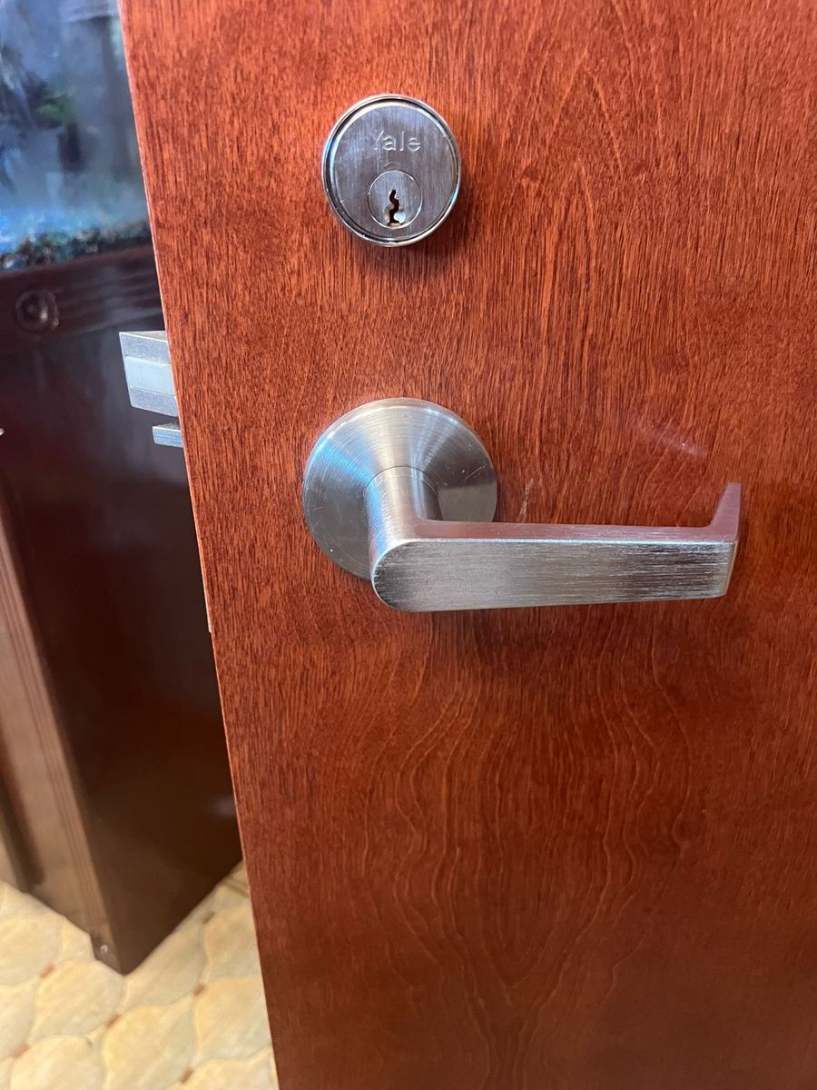 Yale cylinder above a lever on a wood office door